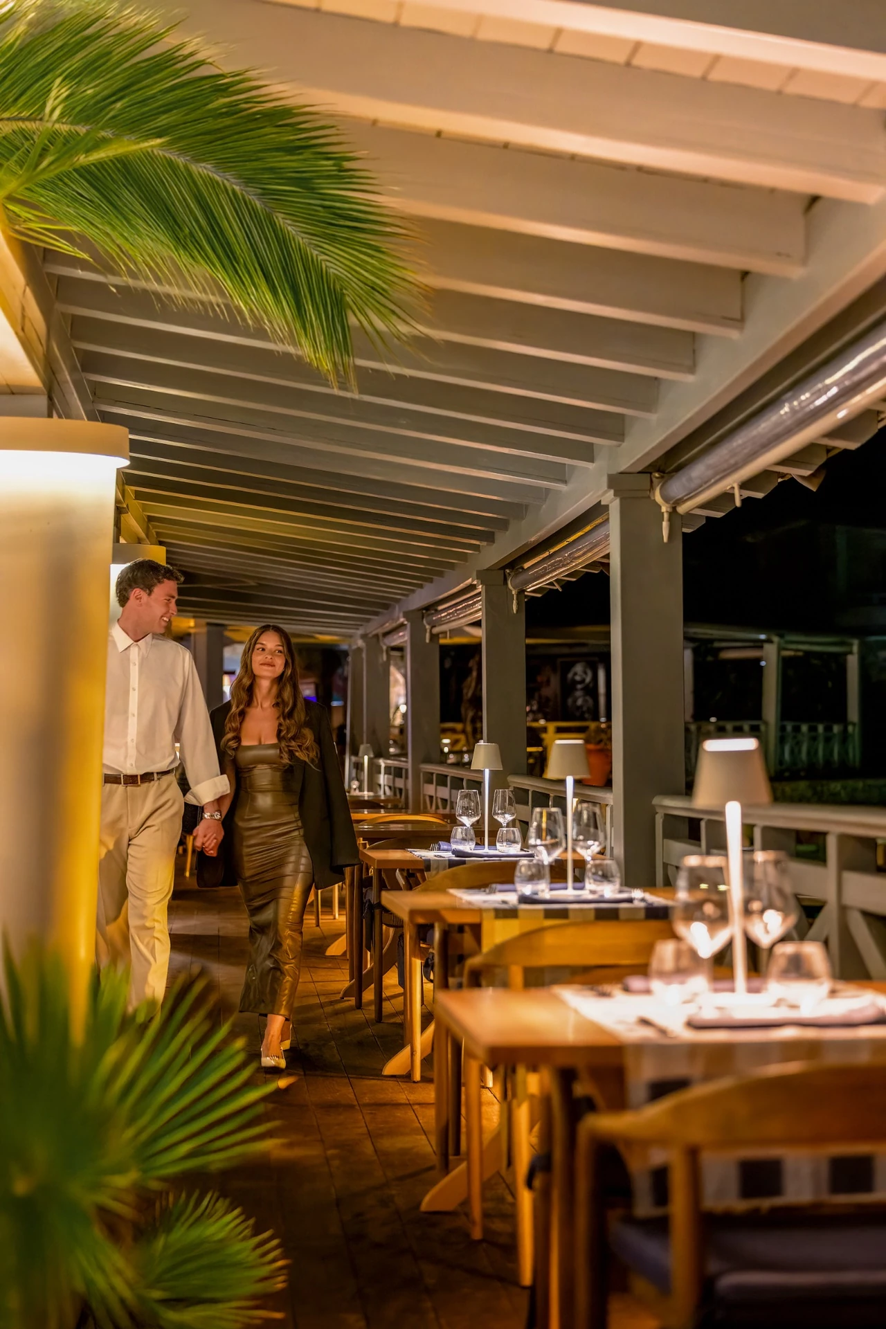 Evening terrace dining on Cavallo — candlelit tables and palm fronds