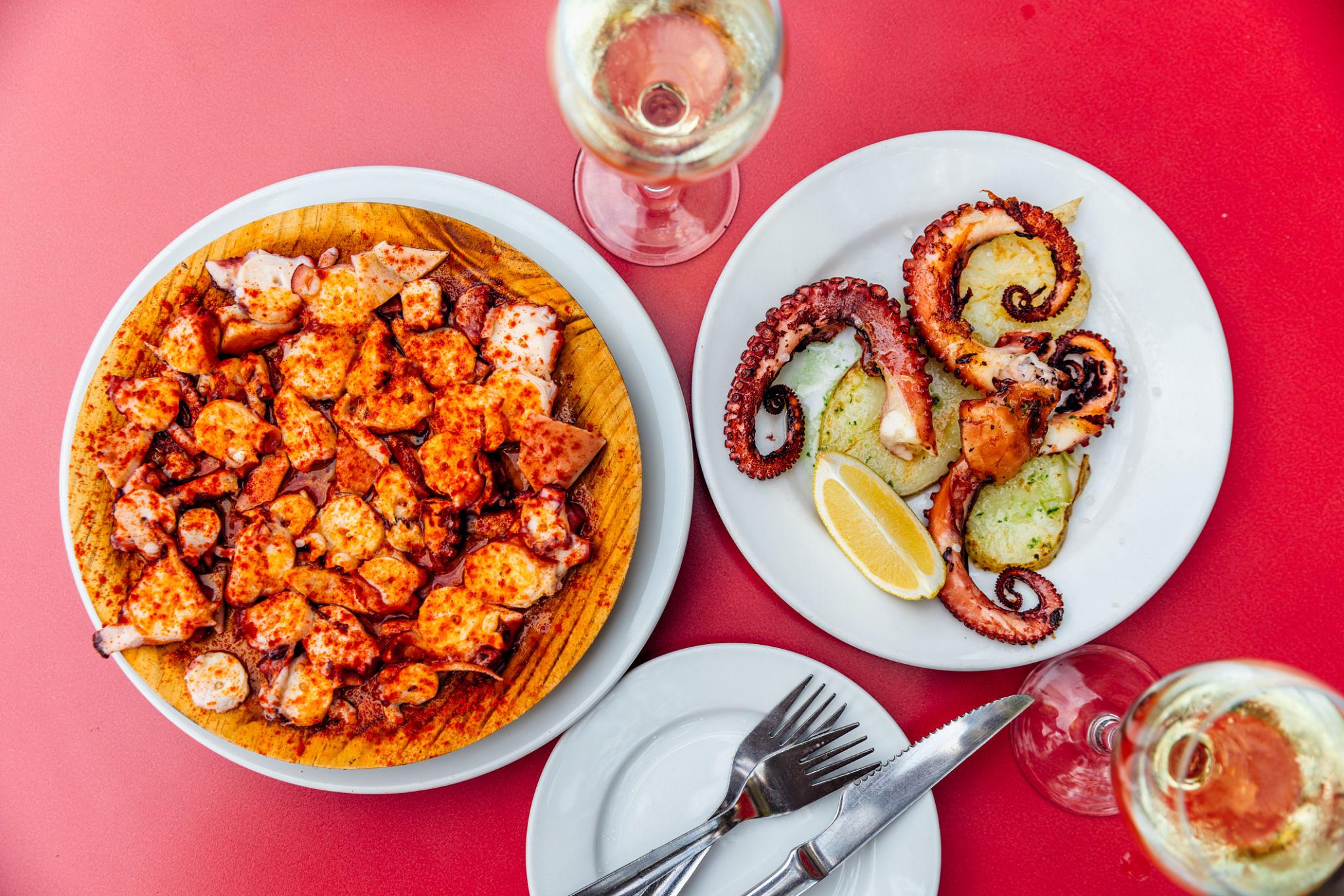 Pulpo a feira on a wooden board and grilled octopus — the defining dishes of Galicia with Albariño wine