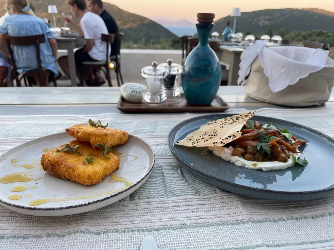 Terrace dining at dusk in Ithaca — saganaki and mezze with mountain views