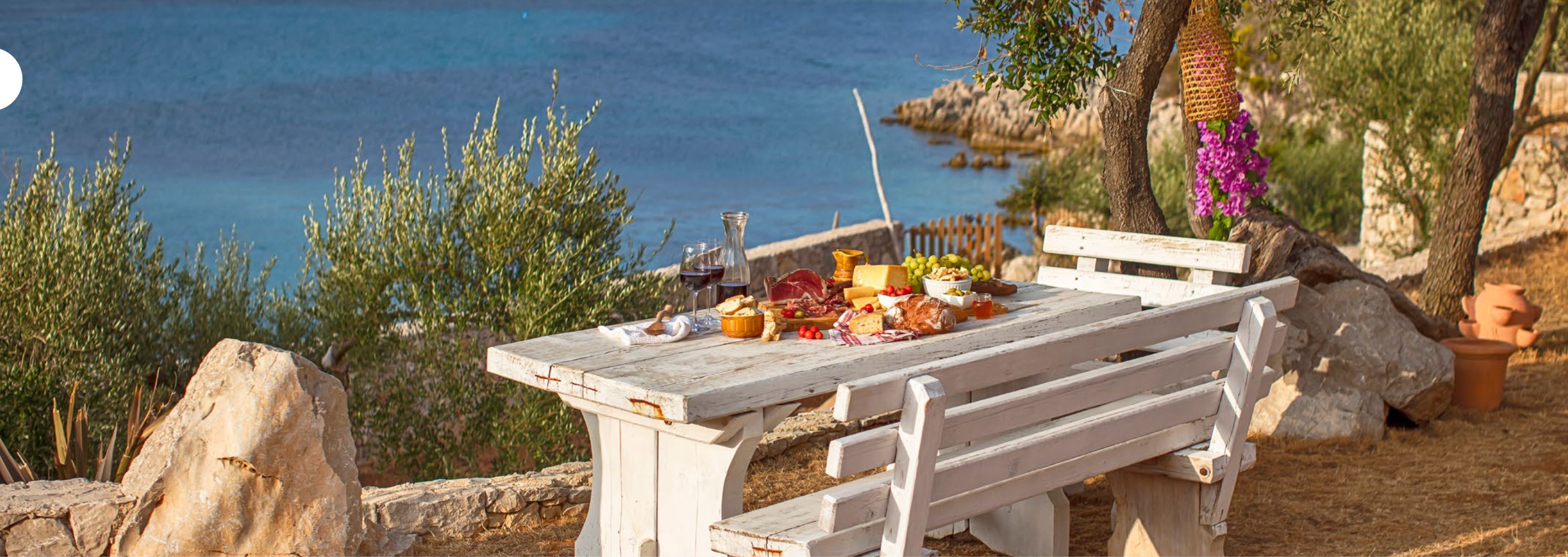 Outdoor dining by the Adriatic — charcuterie and wine beside the sea