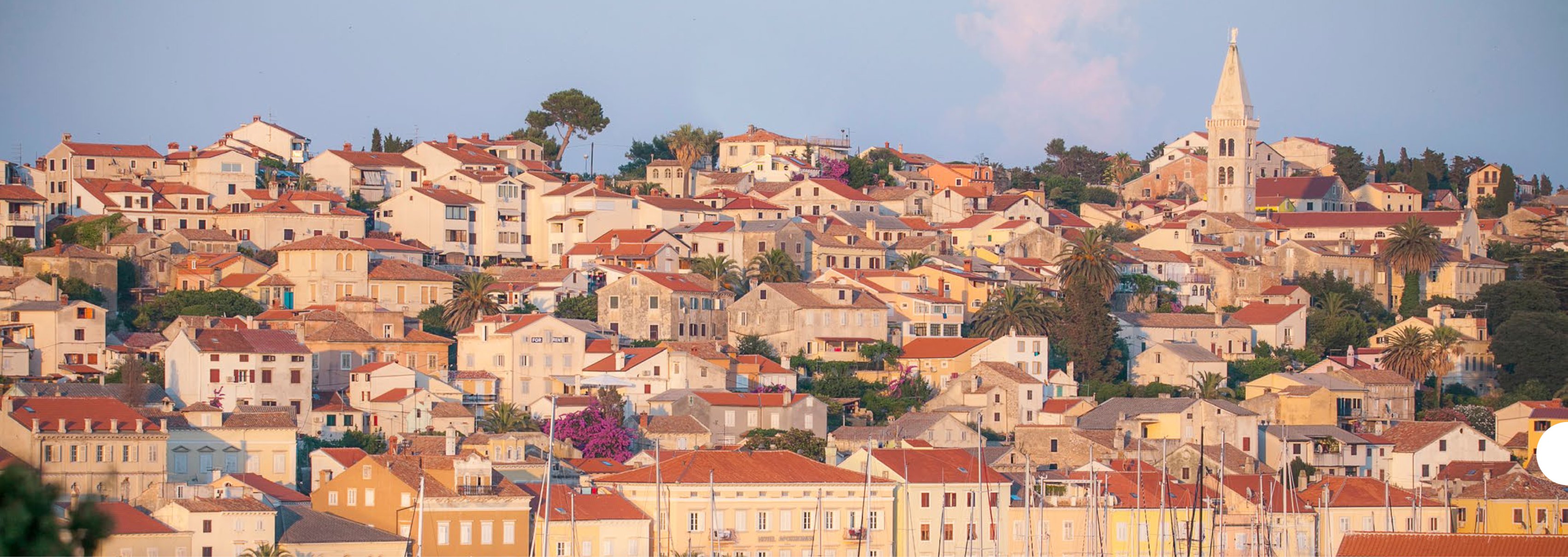 Mali Lošinj townscape — terracotta roofs and church tower at golden hour